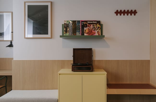 A record player and records on display on a sideboard.