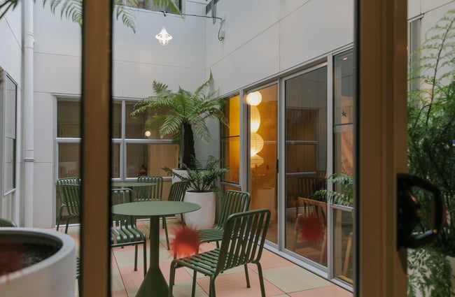 A green table and chairs in an outdoor area.