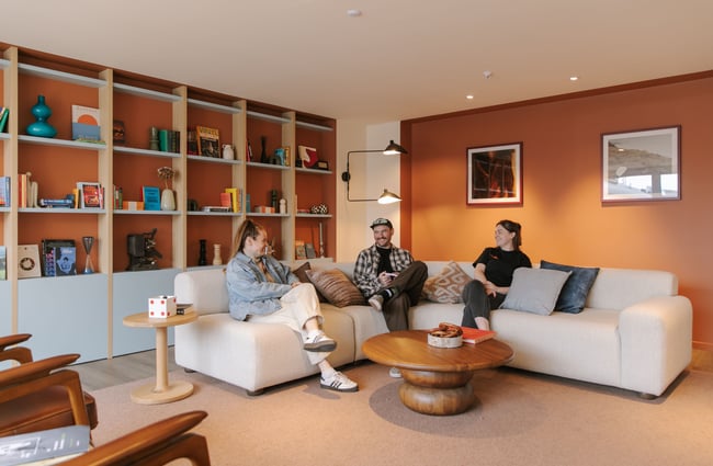 Three people on a couch smiling.