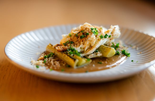 Close up of plate of burrata with braised leek, soubise and toasted breadcrumbs