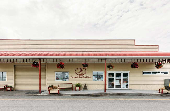 A yellow and red building, the home of Farewell Spit Tours.