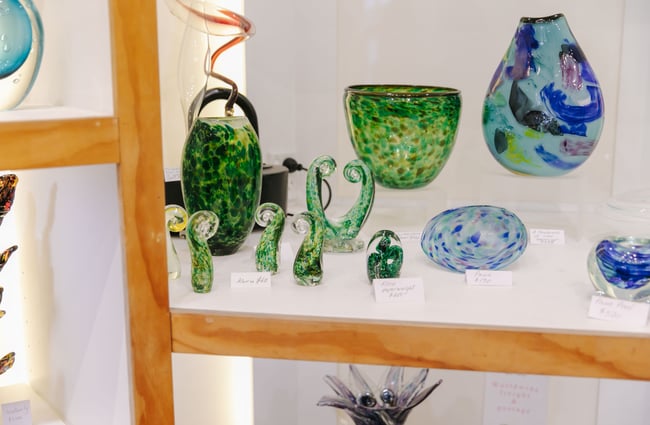 Shelf of blown glass artworks at flamedaisy.