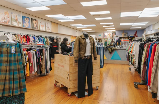 A mannequin dressed in a retro men's outfit in the middle of the store.