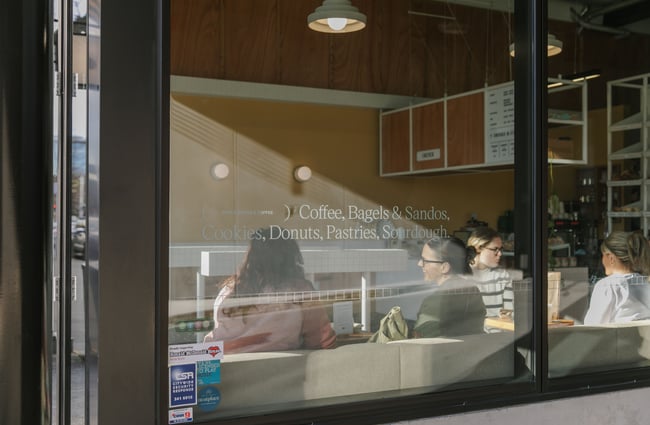 A window sign promoting sourdough, pastries and other baked goods.