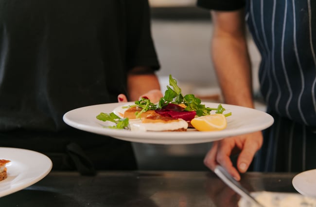 Woman holding plates of food at Hardy St Eatery.