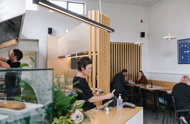 Woman working at the till at Hardy St Eatery.