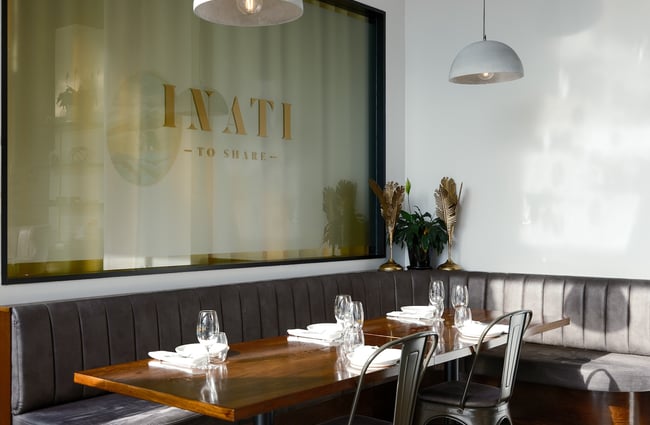 Sunshine illuminating a corner booth in Inati's dining area.