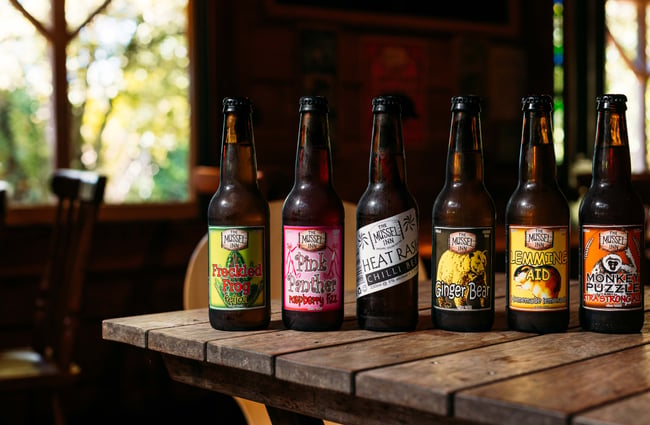 Bottles of beer lined up on a wooden table.