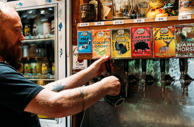 A close up of a man pouring beer.