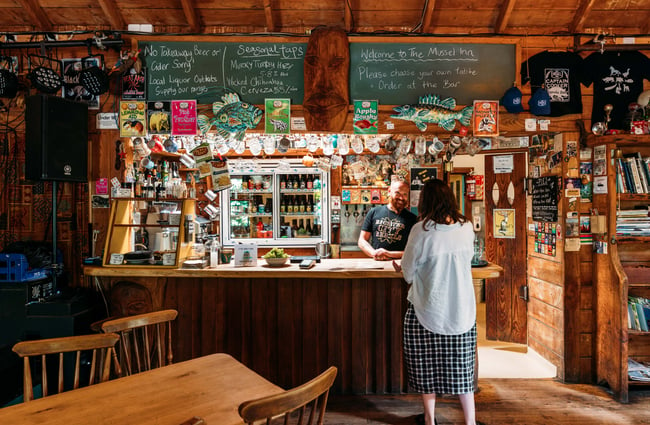 A customer ordering at the bar inside Mussel Inn.