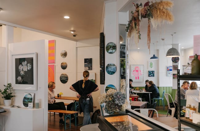 Woman talking to a table of customers at Red Gallery and Cafe.