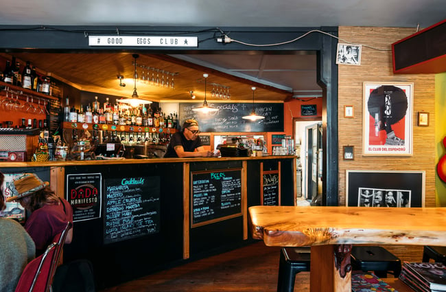 A staff member leaning on the bar counter.