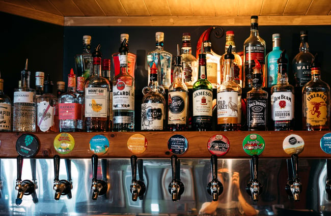 Liquor bottles lined up on a shelf.