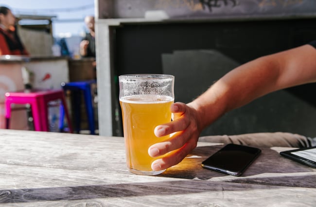 Close up of a hand touching a beer.