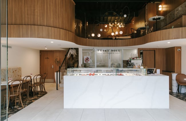 The large white counter and cabinet within an open cafe space.