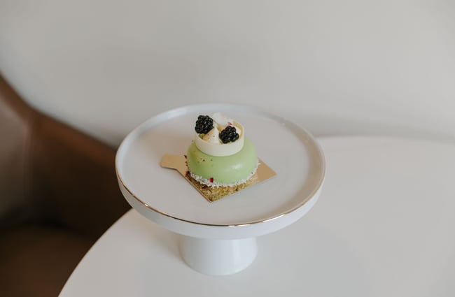 A close up of a green cake on a white table.