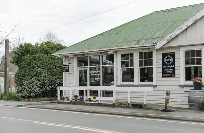 The exterior of the Tasteology artisan store with a sage green roof.