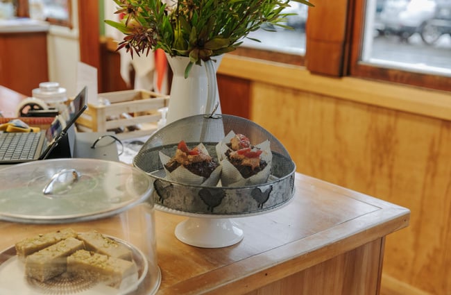 Cake trays and plates of cabinet food like muffins and slices.