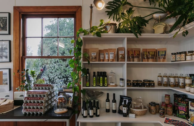 Shelves covered in different oil bottles, bags of nuts and pasta and jars of chutneys.