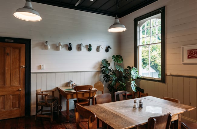 Wooden tables and chairs in a corner of the cafe.