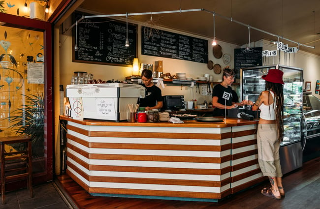 A customer standing at the counter with two staff members working behind it.