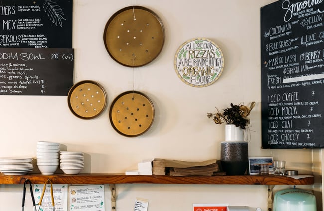 Empty pizza pans decorating a wall inside The Dangerous Kitchen.