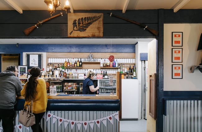 Woman serving customer at the bar at The Fort Enfield in Waitaki.