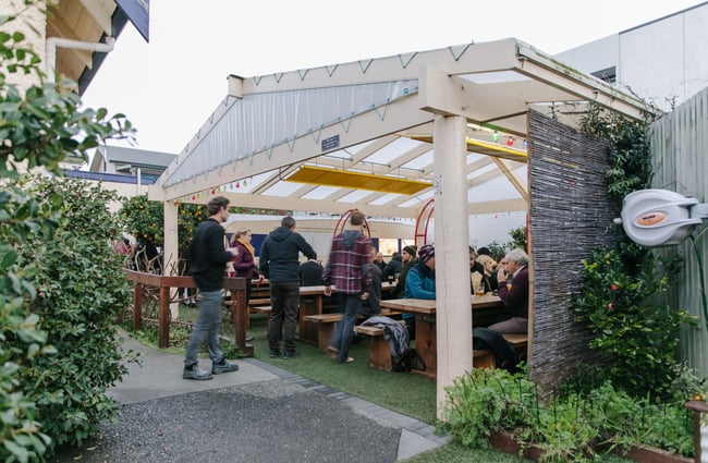 People sat outside on bench seating at The Free House.