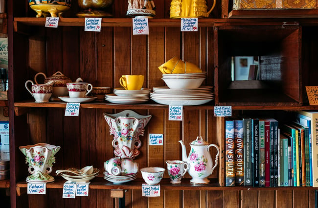 Books, plates and saucers on a table.