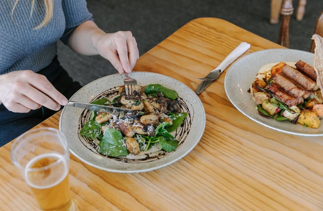 Woman eating gnocchi from The Moutere Inn, Nelson Tasman.