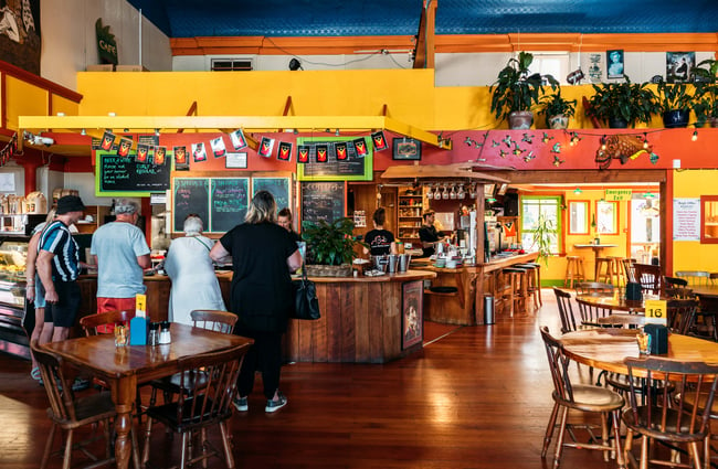 Customers standing the cafe counter.