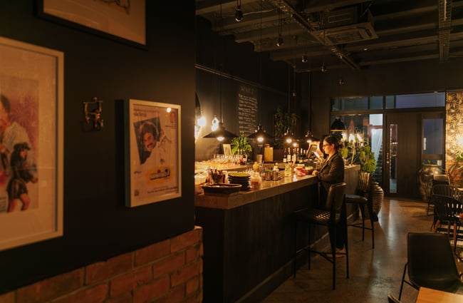 A woman standing at the bar inside Tiger Baby.