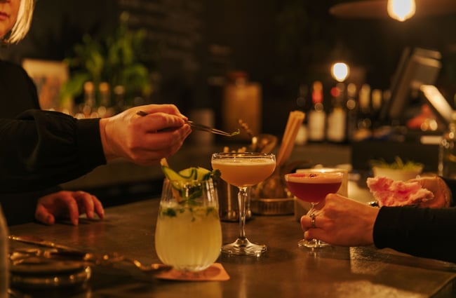 Cocktails being made at a bar.