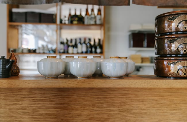 Grey rice bowls with lids on the counter of the kitchen.