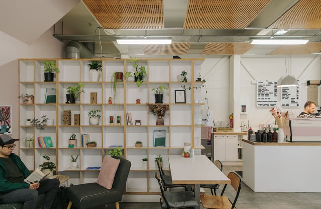 Interior of Victus Coffee & Eatery with a wall of wooden and white shelves.