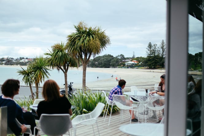 People dining outside a cafe at the beach.