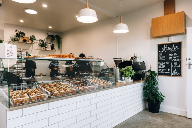 Donut shop in New Plymouth with a cabinet full of donuts and coffee menu board