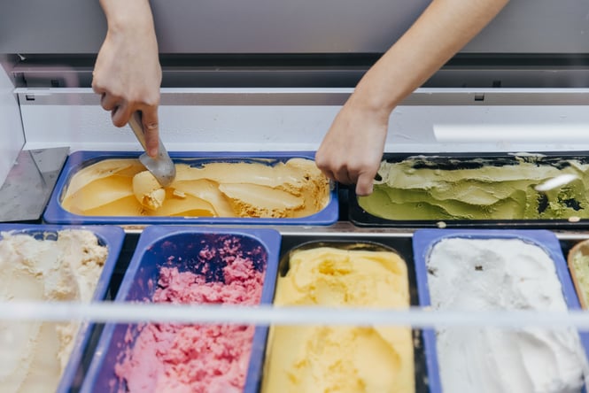 A hand scooping gelato.
