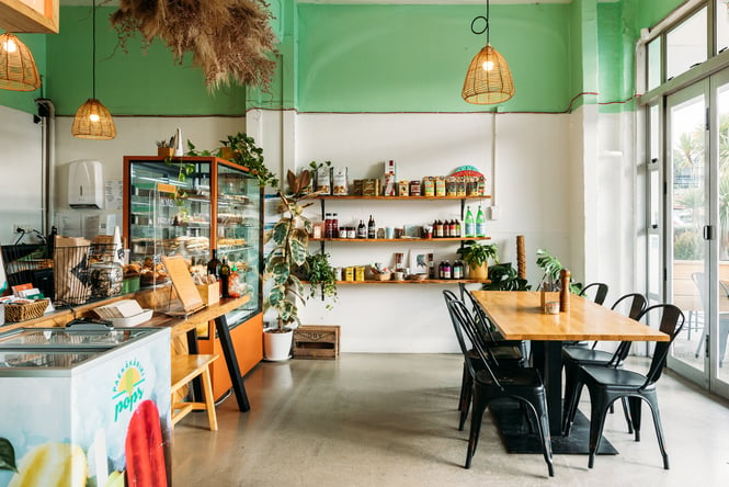 A green and white painted interior of a brightly lit cafe.