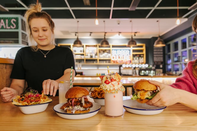 Woman about to eat a burger at Burger Culture.