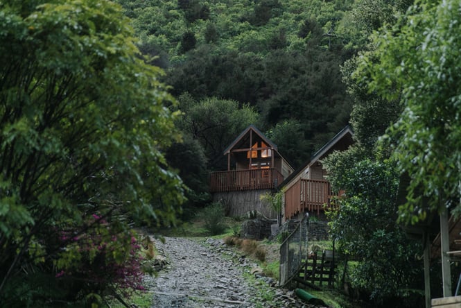 The wooden cabin set amongst bush.