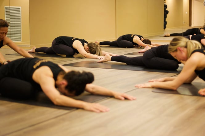 Women stretching on the ground.