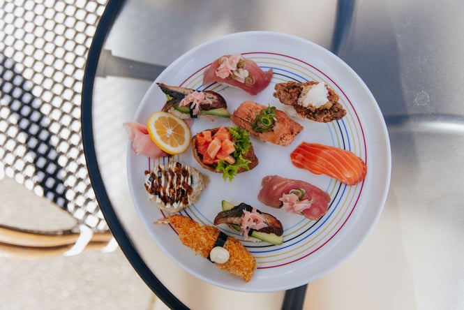 Colourful sushi on white plate with coloured rings.