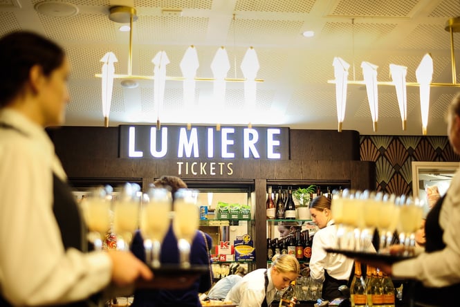 Staff holding drinks and working behind the bar at Lumiere Cinema.