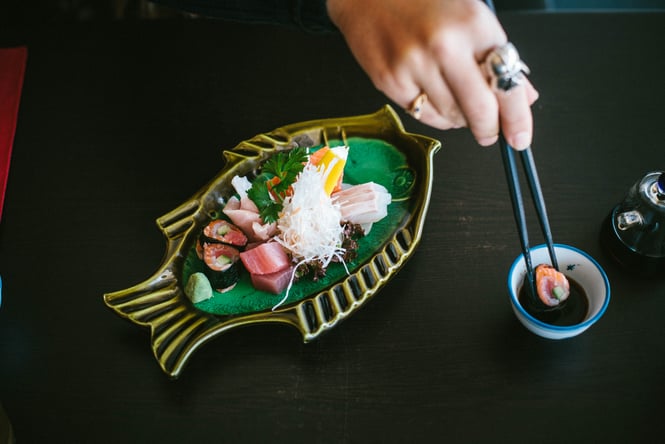 Sushi presented on a fish-shaped plate next to a small bowl of soy sauce at Cookai Gold in Christchurch