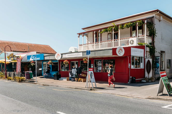 Shops lined in a row in Golden Bay on a sunny day.