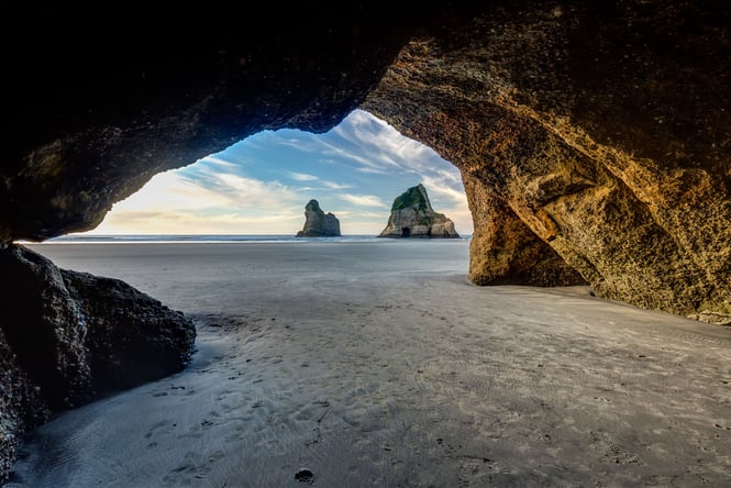 Inside a cave at Wharariki Beach on a sunny day.