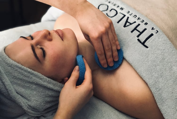 A woman draped in a blue towel getting a facial  at Total Body Concept in Christchurch.