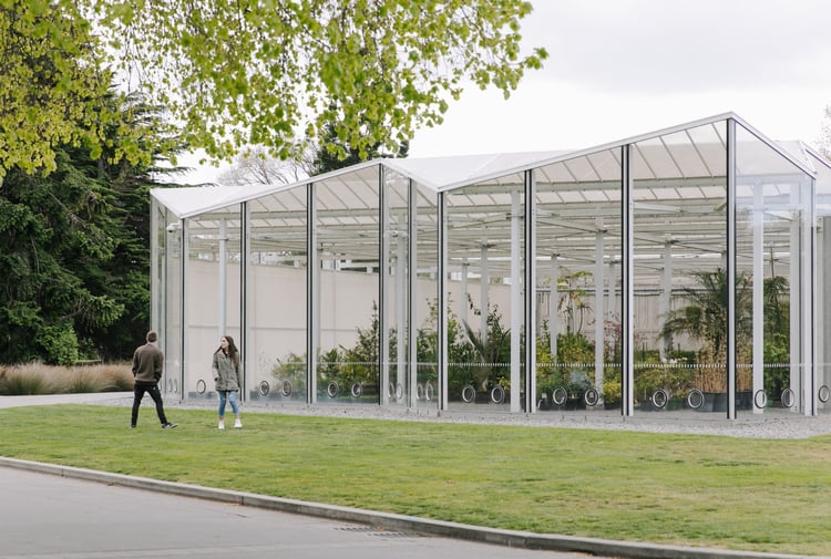 Two people spending time outside a glasshouse at Christchurch Botanic Gardens.