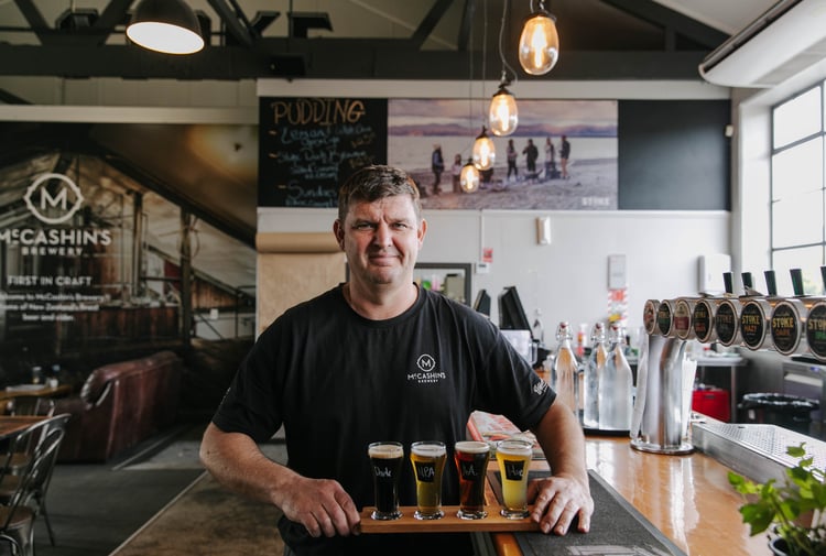 Man holding beer flight from McCashin's.